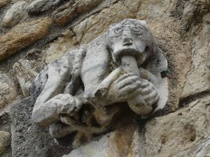 Détail du portail représentant un simiot mangeant un serpent